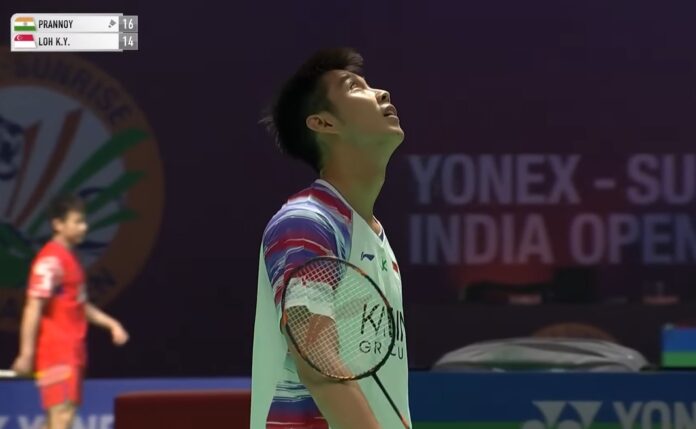 싱가포르의 로 킨 유(Loh Kean Yew)는 2026년 인도 오픈에서 HS 프라노이(HS Prannoy)와의 2라운드 경기 도중 경기를 잠시 멈추고 자신의 코트에 똥을 싼 새를 쳐다보고 있습니다. (사진설명: BWF)